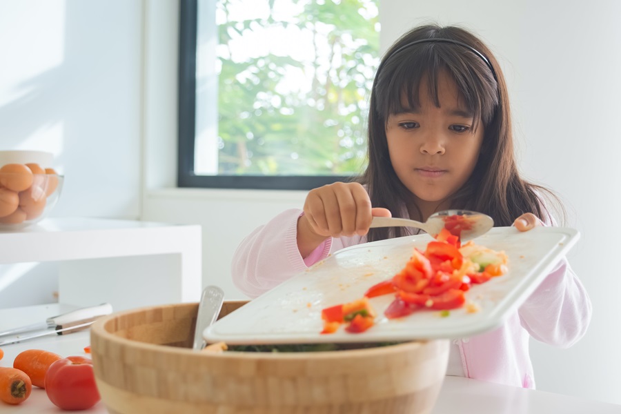How Standard Process Congaplex Helps when you are Sick a Young Girl Scraping Diced Veggies Into a Salad Bowl