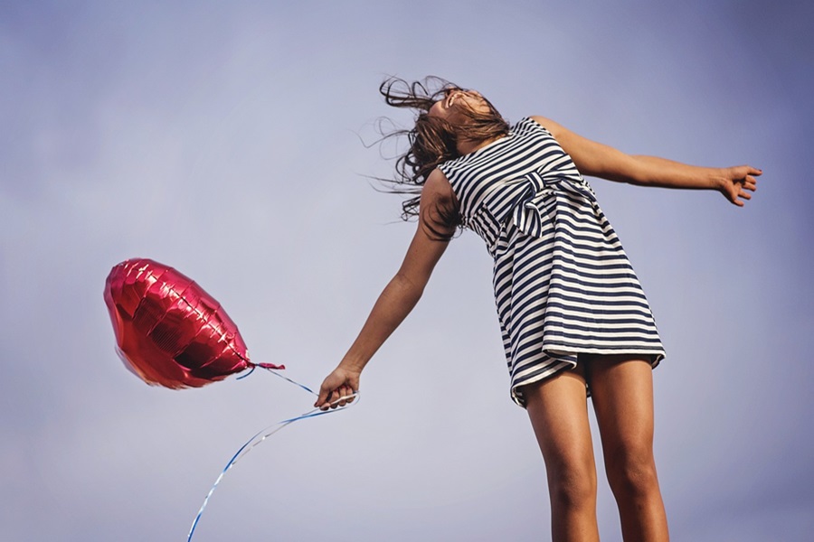 Standard Process Congaplex a Woman Jumping Into the Air Holding a Heart-Shaped Balloon