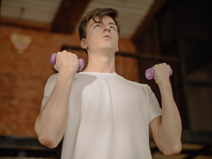 Weekly Jillian Michaels Workout Routines Close Up of a Young Man Doing Bicep Curls with Dumbbells