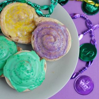 Everyone will love this Mini King Cake Recipe that is easy to make and full of color! The best part is, kids can help make this one. What is a Mini King Cake | What is a King Cake | How to Make a King Cake | How to Make Mini King Cakes