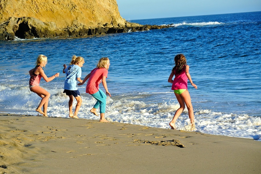 Family Things to do in Orange County a Group Of Kids Running into the Ocean From a Beach