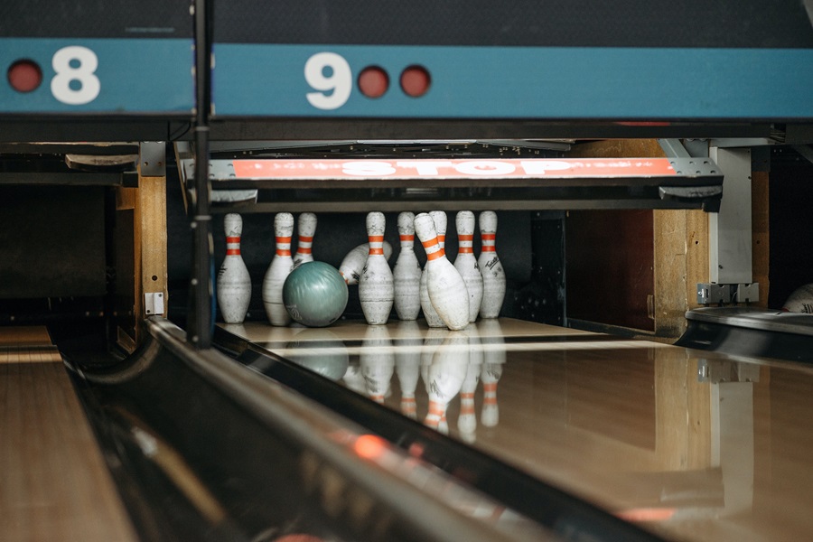 Family Things to do in Orange County View of a Bowling Alley Lane with a Ball Hitting the Pins at the End
