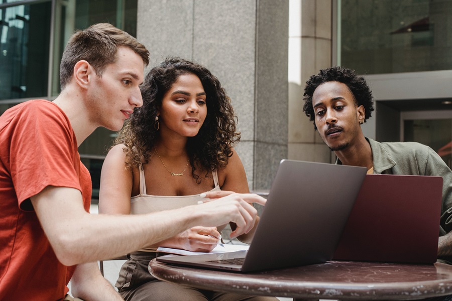 Microsoft Sway Tutorial a Group of People Working on Two Laptops Outdoors at a Cafe Table