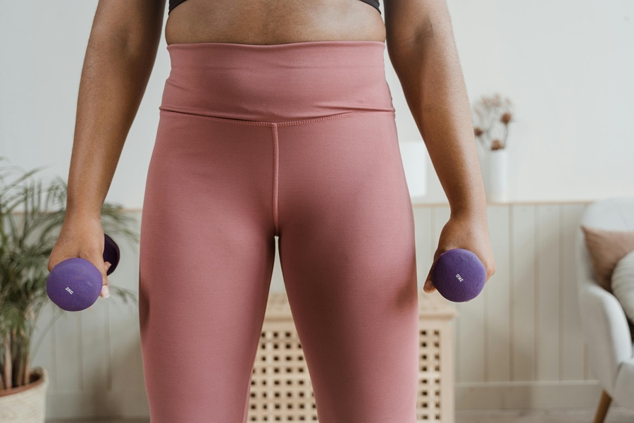 Jillian Michaels Body Revolution Close Up of a Woman Wearing Workout Clothes Holding Two Dumbbells
