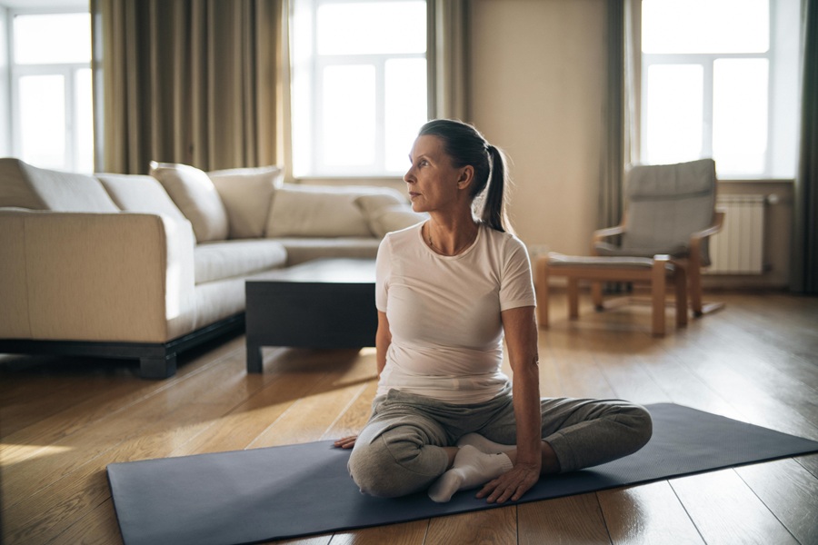 Jillian Michaels Body Revolution a Woman Wearing Workout Clothes Sitting Cross-Legged on a Yoga Mat