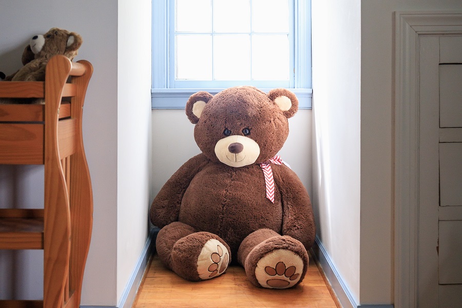 Stillbirth Quotes to Help you Cope an Oversized Stuffed Teddy Bear Sitting Under a Window in a Nursery