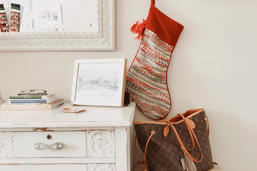 Stocking Stuffers for Women Stocking Hanging on a Wall Above a Purse Next to a Mirror