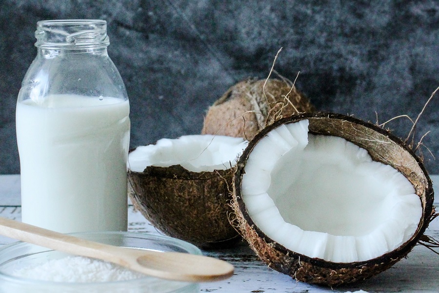 No Dairy Diet A Glass of Coconut Milk with Coconuts Surrounding It