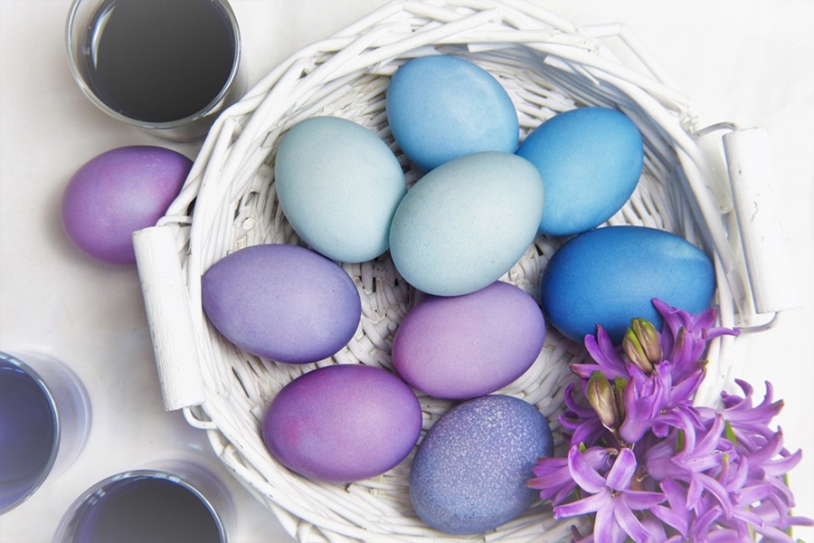 DIY Peeps Crafts For Any Age a White Basket of Dyed Easter Eggs in Shades of Blue and Purple