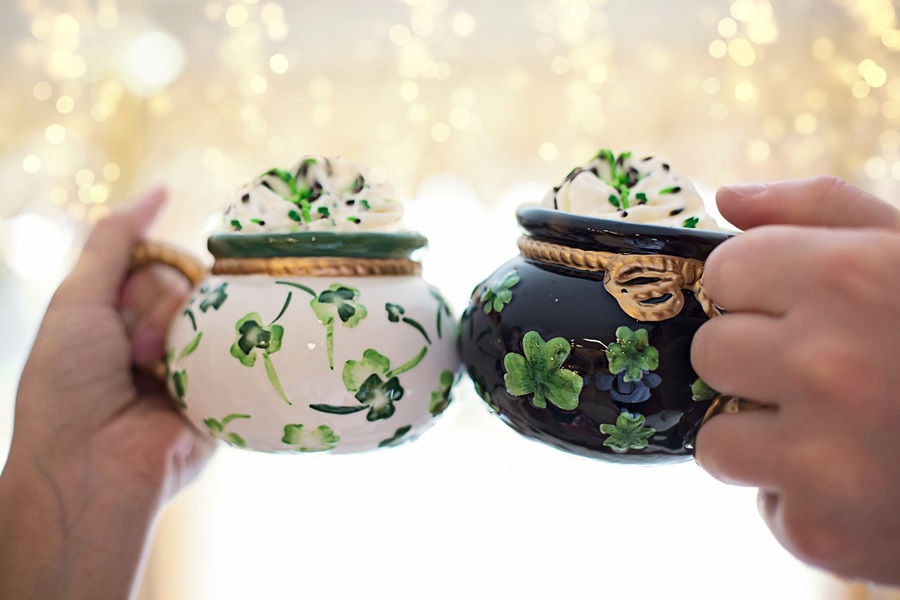 Green Drinks For Kids and Adults Close Up of Two Mugs Shaped Like Pots of Gold Being Clinked Together