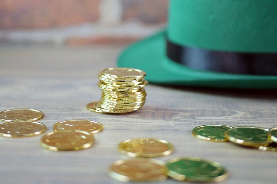 Green Drinks For Kids and Adults Close Up of Gold Coins Scattered and Stacked on a Table with a Green Hat in the Background