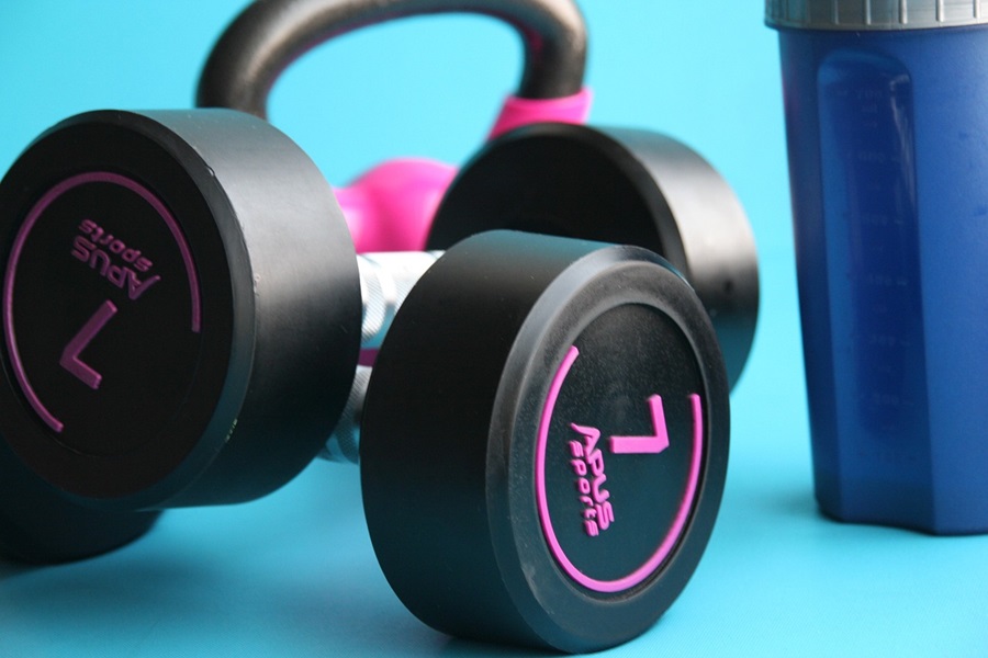 How Long are Cize Workouts Close Up of Workout Gear Including Dumbbells, Kettlebells and a Water Bottle