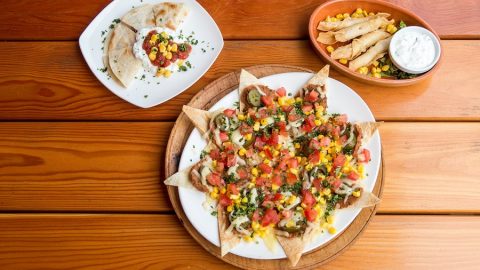 Cinco de Mayo Foods Overhead View of Nachos, a Qusadilla, and Taquitos on a Table