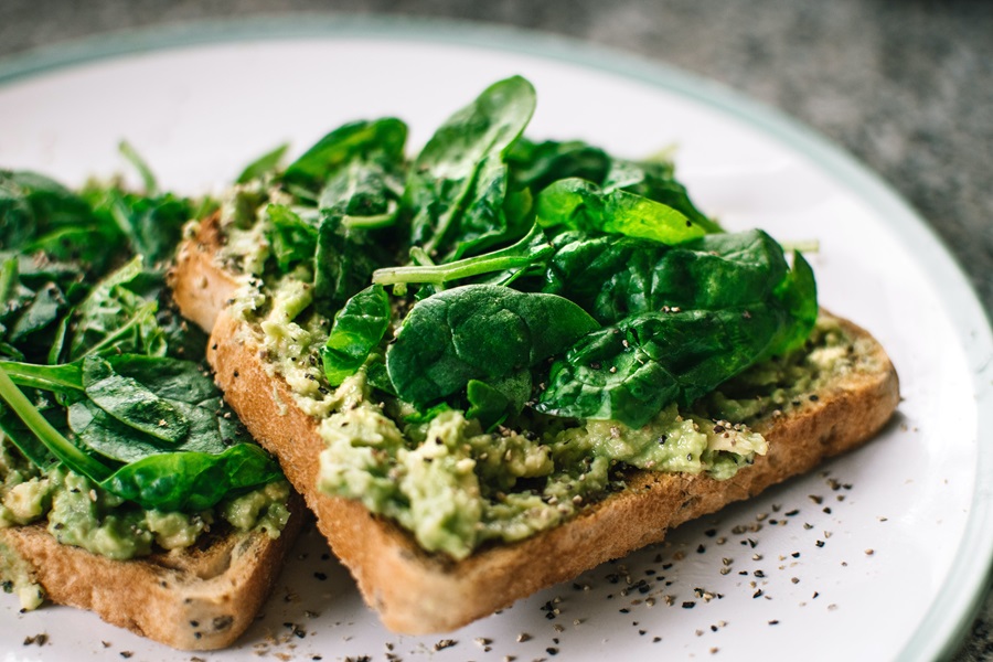 Jillian Michaels Body Revolution Meal Plan Tips Close Up of Avocado Toast Topped with Spinach