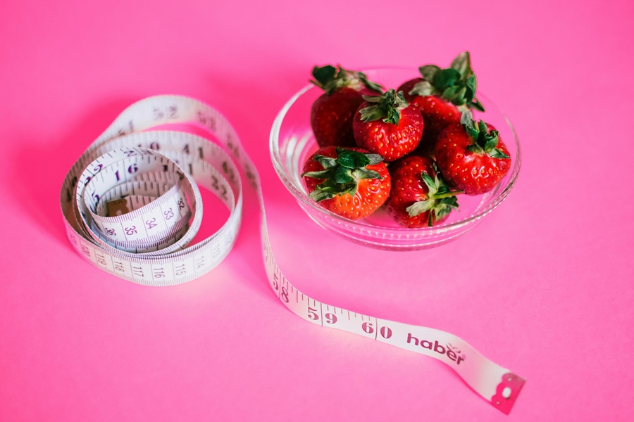 Jillian Michaels Body Revolution Meal Plan Tips Strawberries Wrapped in a Tape Measure on a Pink Surface