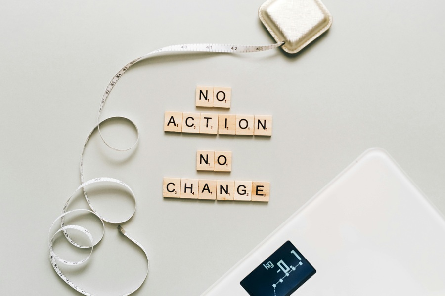 Jillian Michaels Body Revolution Meal Plan Tips Letter Tiles Spelling Out No Action No Change Next to an Unfurled Tape Measure and a Scale