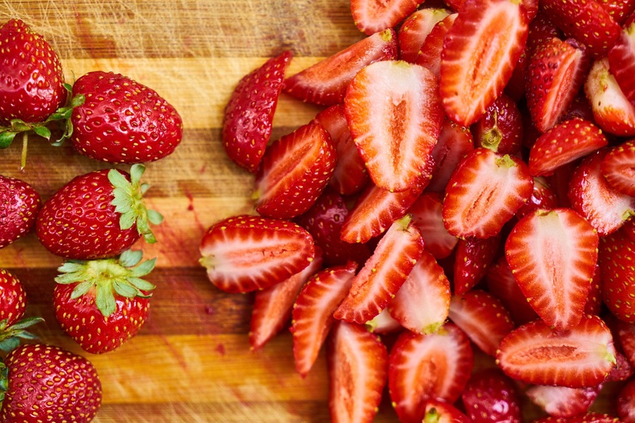 How to Go Dairy Free Sliced Strawberries on a Wooden Cutting Board