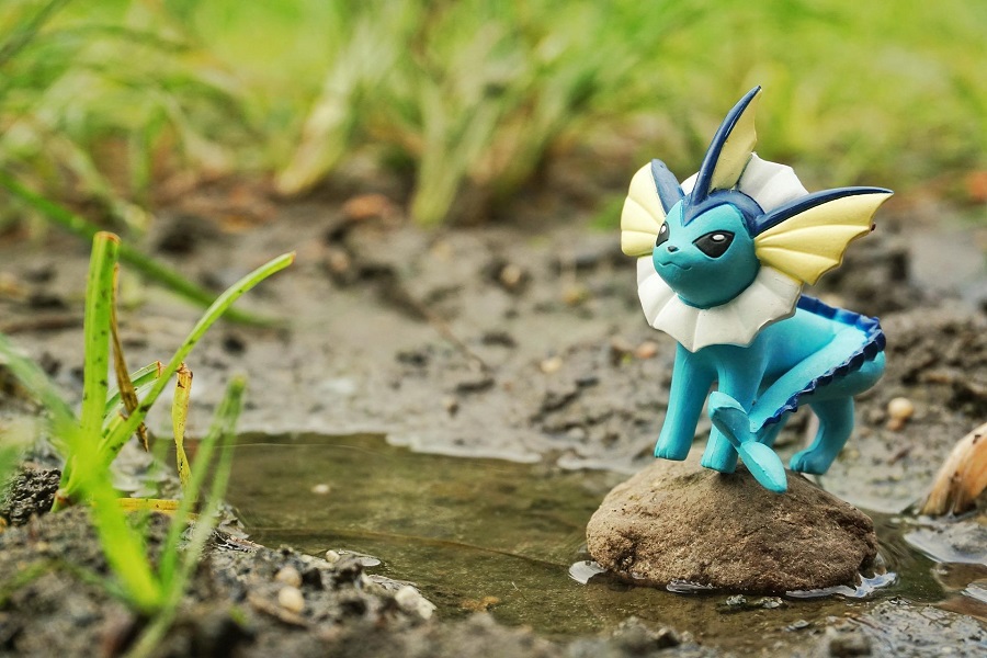 Pokemon Cake Ideas Vaporeon Toy Sitting Next to a Puddle of Water Outside