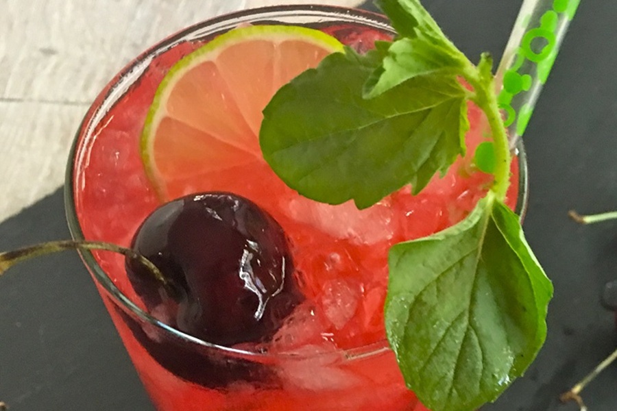 Homemade Blackberry Mojito Recipe Close Up of a Blackberry Mojito Garnished with a Cherry, Lime Slice, and Mint Sprig
