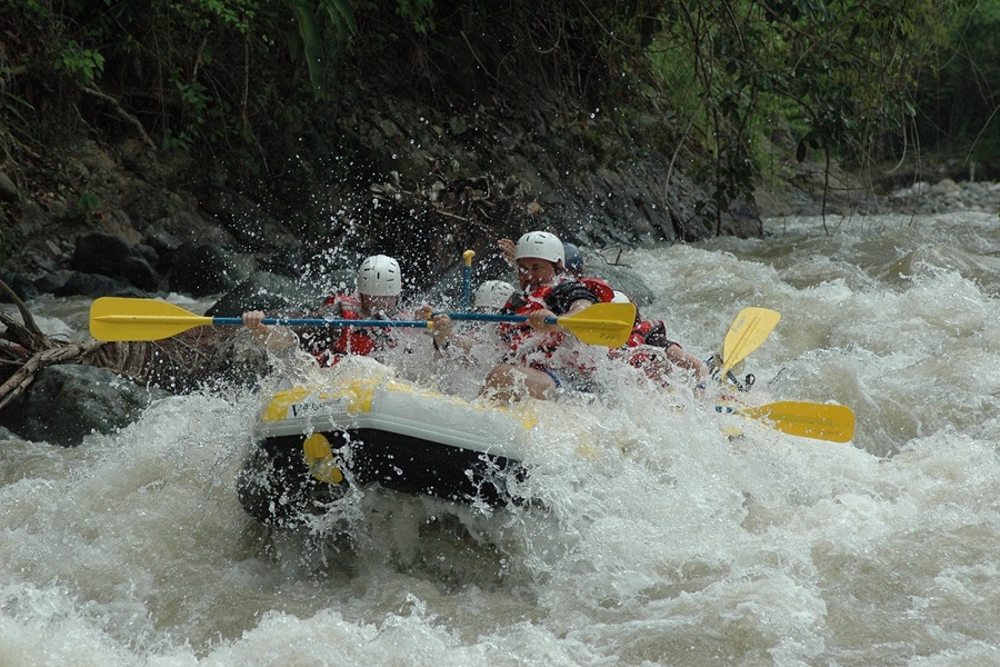 Whitewater Rafting Terms and Lingo To Know View of a Yellow Raft Covered in White Water on a River