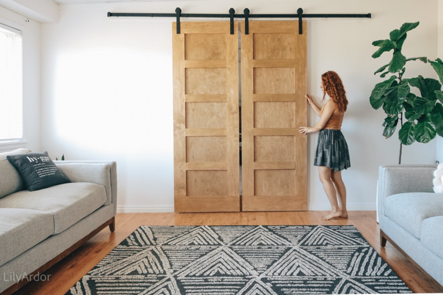 Closet Doors DIY Tutorial with Photos a Woman Closing Barn Door Style Doors in a Living Room