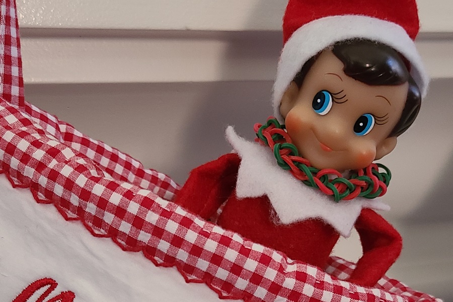 Elf on the Shelf Shopping List for 35 Ideas Close Up of an Elf Sitting in a Stocking Hanging From a Fireplace Mantel