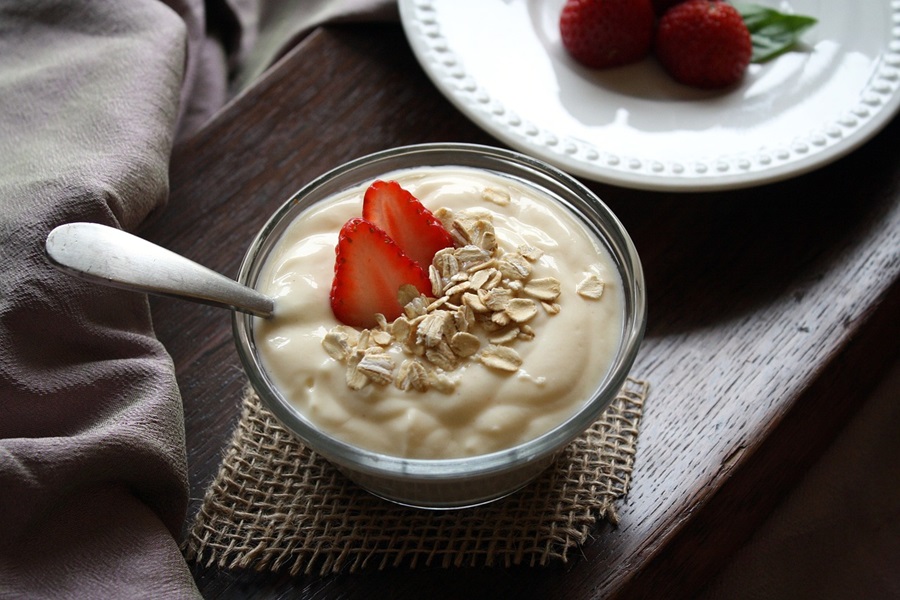 Slimming Foods To Eat a Small Bowl of Yogurt Topped with Strawberries and Oats