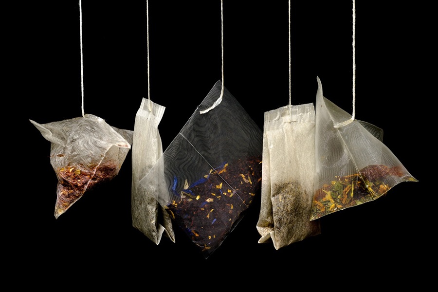 Slimming Foods To Eat a Row of Tea Bags Hanging Against a Black Background