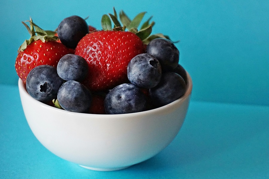 Slimming Foods To Eat Close Up of a White Bowl of Blueberries and Strawberries