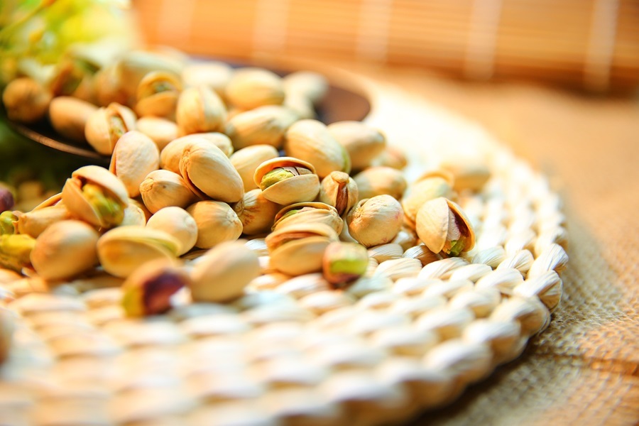 Slimming Foods To Eat Close Up of a Bunch of Pistachios on a Wicker Mat