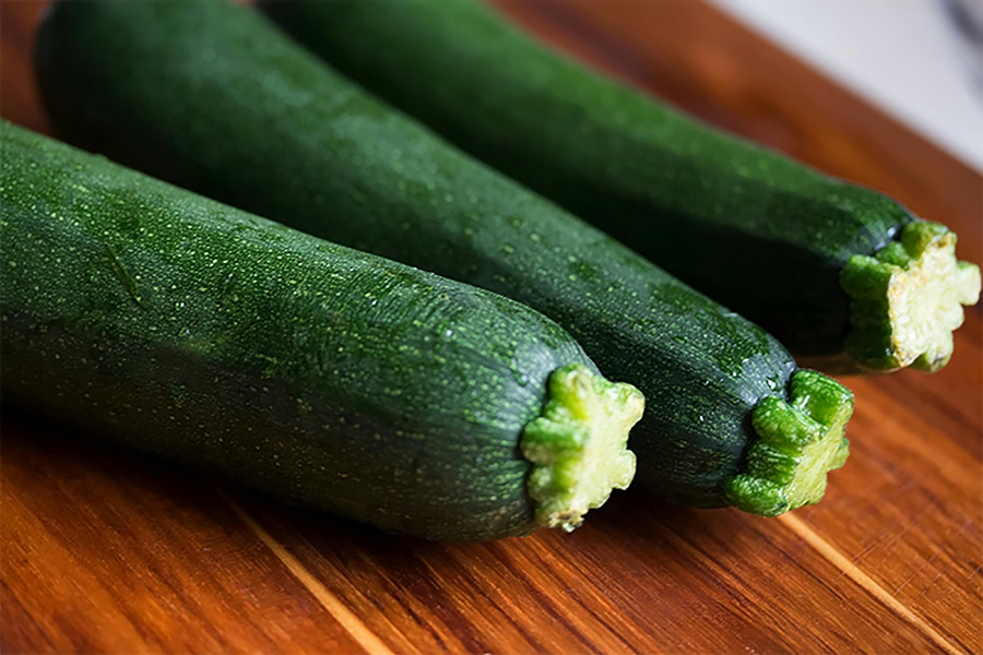 Slimming Foods To Eat Close up of Three Cucumbers on a Wooden Surface