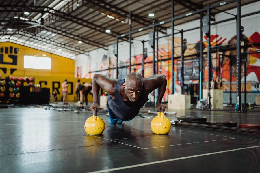 Core De Force Review a Man Doing Pushups Using Kettlebells To Hold Him Higher