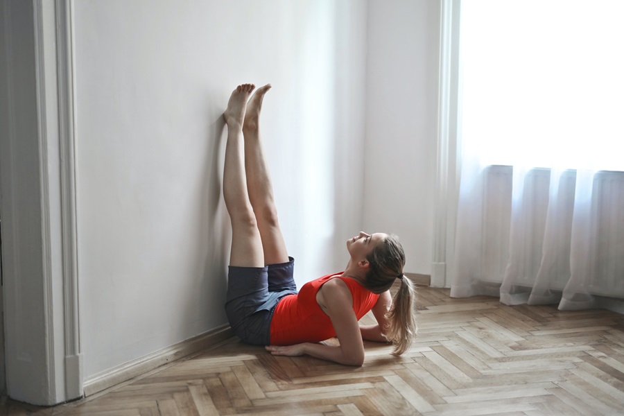 Core De Force Review a Woman Stretching with Her Legs Up Against a Wall