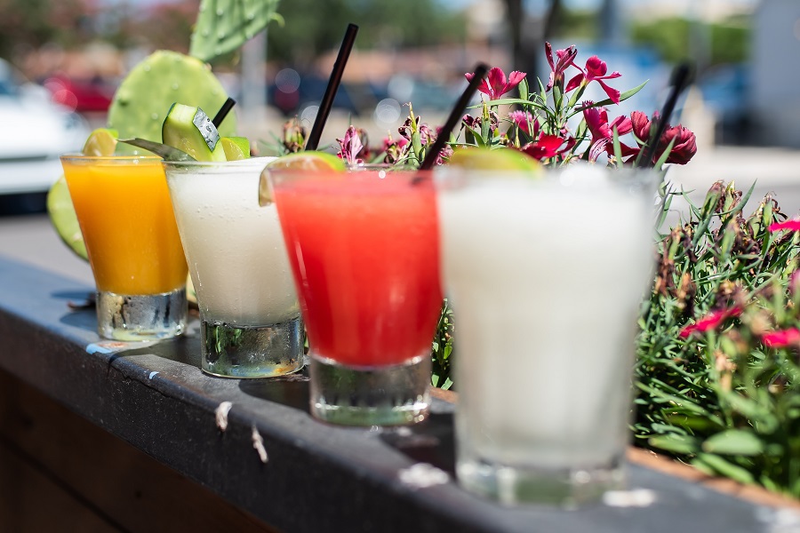 Patron Lime Liqueur Recipes Four Margaritas Sitting on a Fence with Flowers in the Background