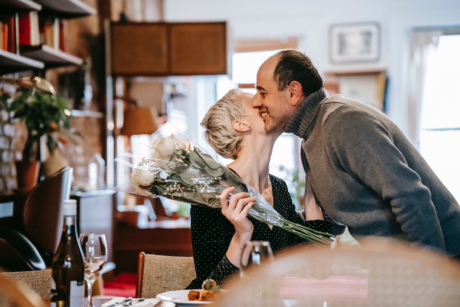 Valentines Day Desserts a Man Giving His Partner Flowers While Kissing Her at the Counter