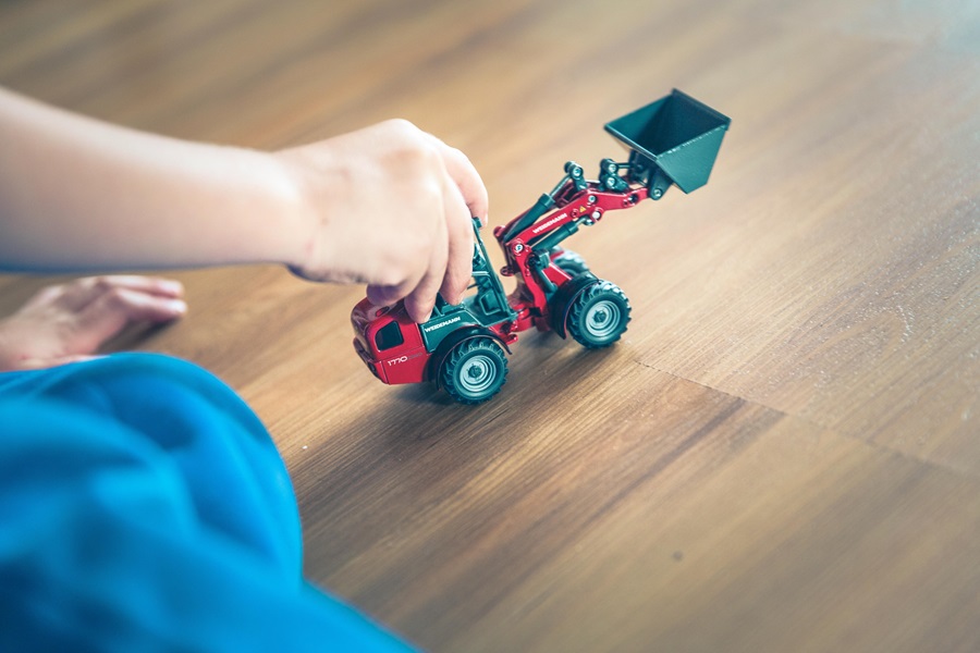 Activities for Kids Before Electronics Close Up of a Toy Tractor with a Child's Hand on it