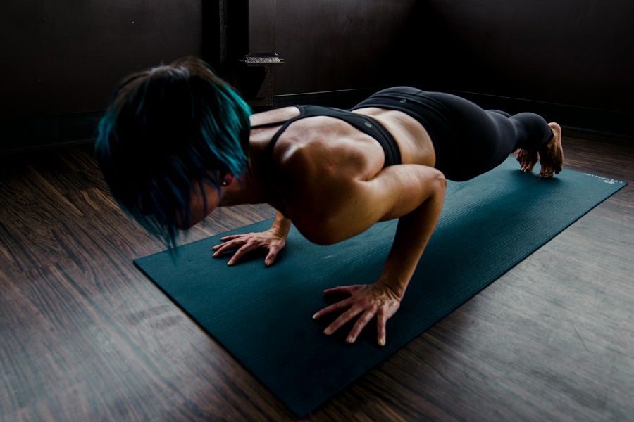 Shaun Week Workouts A Woman Doing Pushups on a Blue Yoga Mat