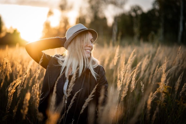 Standard Process Calcium Lactate a Woman Smiling Holding a Fedora on Her Head Sitting in a Field of Wheat