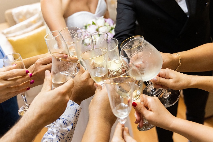 Best Wine Toast Quotes to Say Cheers to Close Up of a Bridal Party Making a Toast at a Wedding