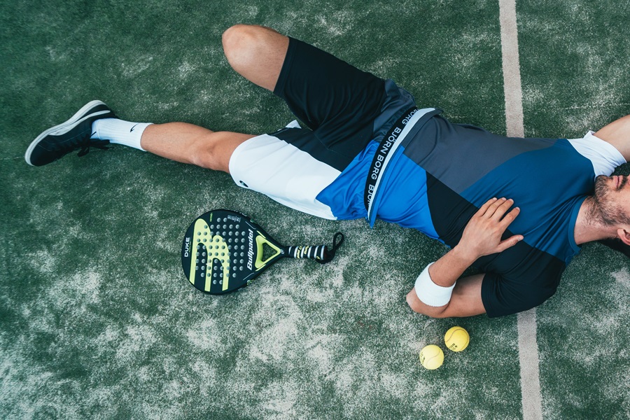 Standard Process Arginex Benefits a Man Laying Down on a Tennis Court with Tennis balls Near His Head and a Racket by His Side