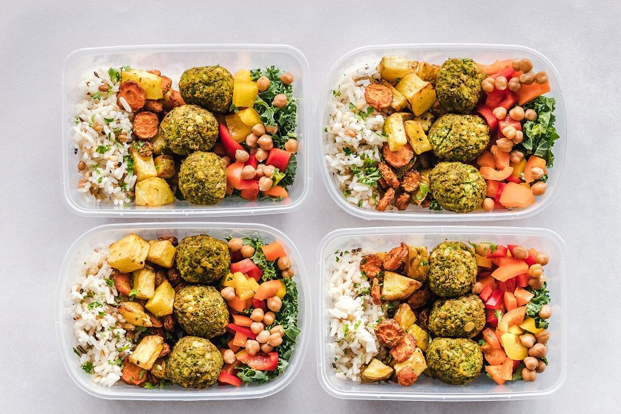 2B Mindset vs 21 Day Fix Overhead View of Four Meal Prep Containers Filled with Healthy Food