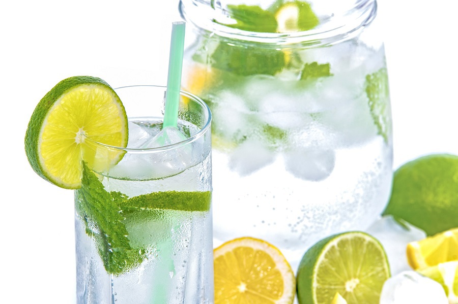 Tips for Starting a Ketogenic Diet Close Up of a Glass of Water Next to a Pitcher of Water with Lemon and Lime Slices