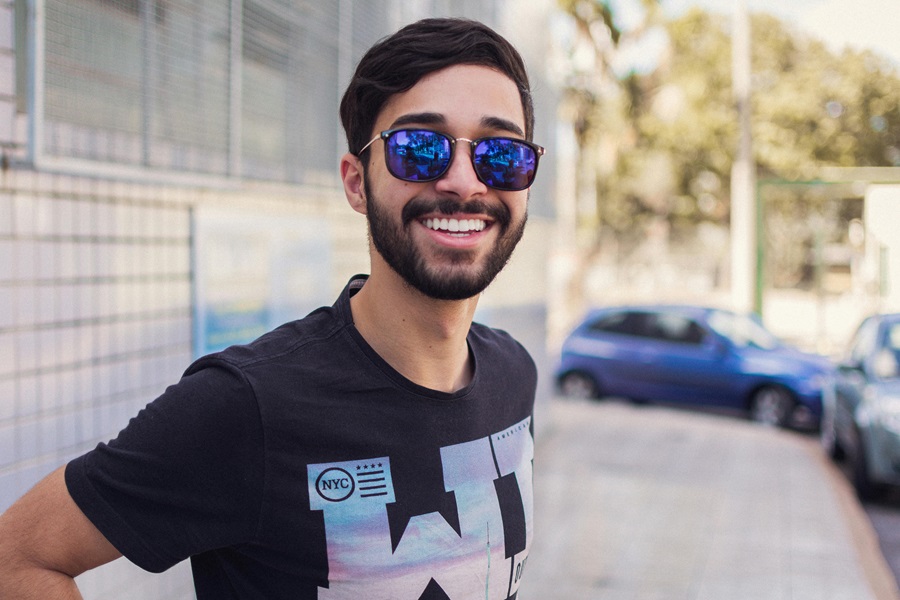 Class 2 Malocclusion with Invisalign® Treatment a man Wearing Sun Glasses Smiling While Standing Outside of a Building