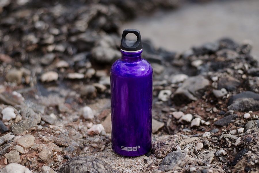 2B Mindset Success Tips a Purple Metallic Water Bottle Sitting on Rocks