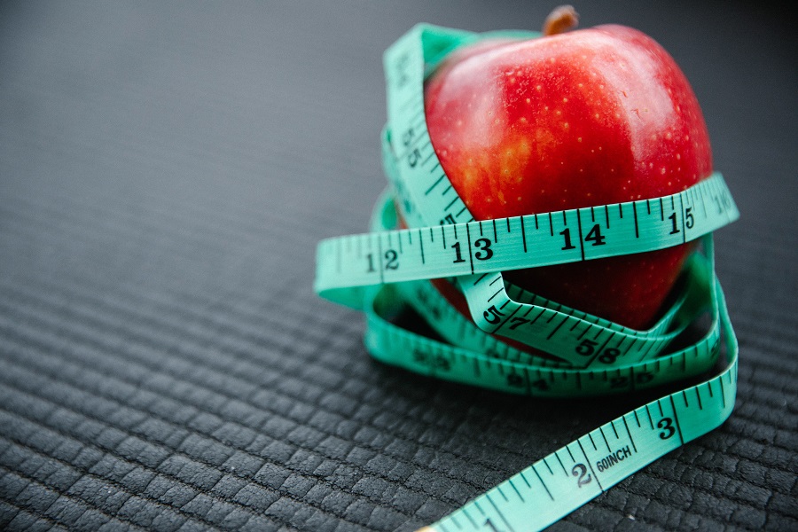 2B Mindset Success Tips Close Up of an Apple with a Teal Measuring Tape Wrapped Around it