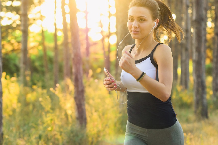 2B Mindset Success Tips a Woman Running While Smiling and with Headphones in Her Ears