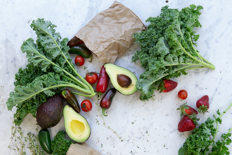 Packable 2B Mindset Meals a Paper Bag Spilled Over with Kale, Avocados, and Tomatoes Coming form The Bag