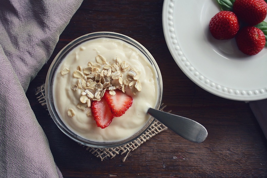 2B Mindset Cost Close Up of a Small Bowl of Yogurt Topped with Strawberries and Oats