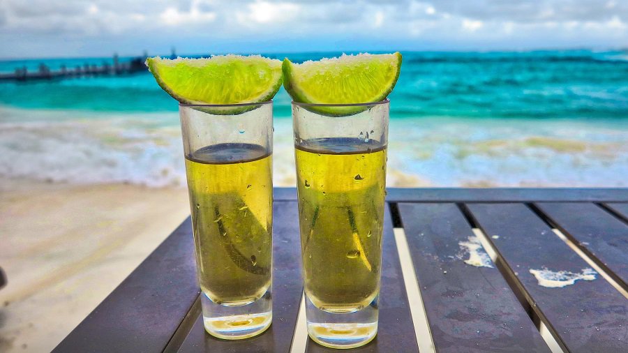 Tequila Facts for your Health Two Shots of Tequila Sitting on a Small Table on a Beach