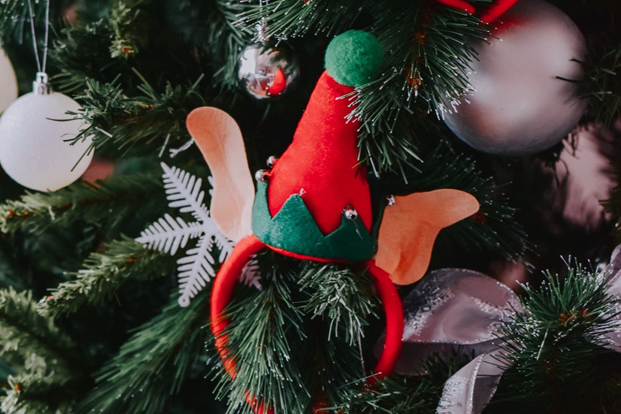 Welcome Back Elf on the Shelf Ideas Close Up of an Elf Ear headband in a Christmas Tree